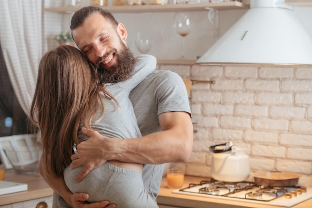 Buona notte abbraccio Famiglia felice Padre amorevole che tiene la sua piccola figlia in cucina sorridente