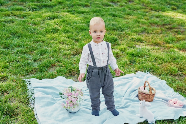 Buona Pasqua. Bambino divertirsi all'aperto. Scherzi il gioco con le uova e il coniglio su erba verde.