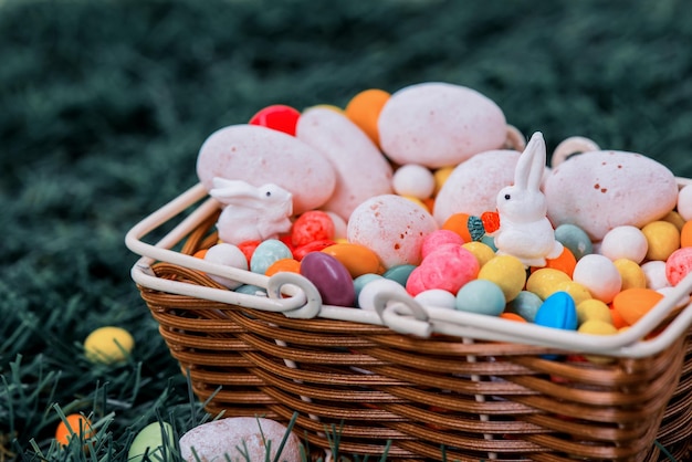 Buona Pasqua, coniglietto e uovo per festeggiare ad aprile. Caramelle dolci con cesto.