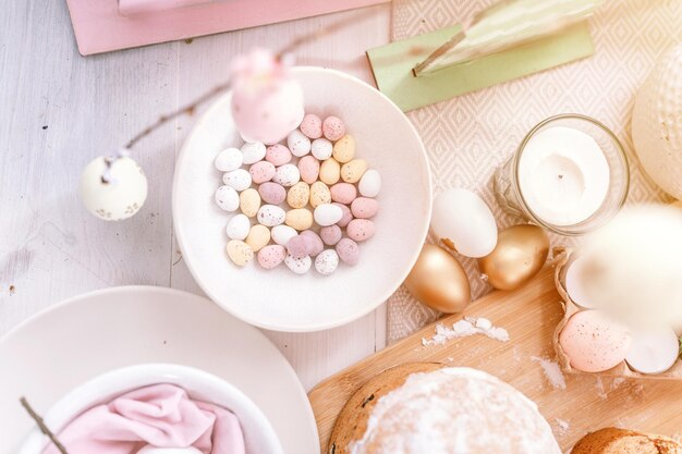 Buona pasqua e vacanze primaverili tempo festivo tablescape set arredamento cena tradizionale cibo uova di pasqua e torte al forno sul tavolo a casa pallido pop colore pastello blu e rosa vista dall'alto bagliore