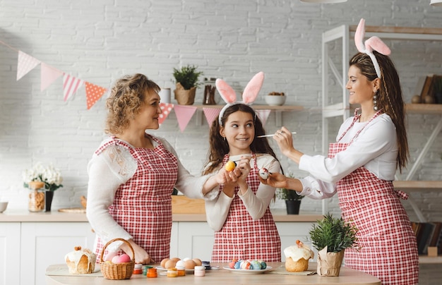 Buona Pasqua Madre e figlie disegnano le uova di Pasqua Una famiglia felice si sta preparando per la Pasqua