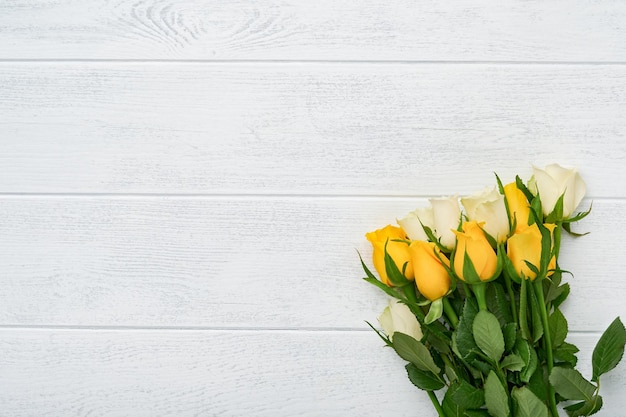 Buona Pasqua Rose gialle e bianche su fondo di legno bianco Sfondo di Pasqua con spazio di copia Motivo floreale Biglietto di auguri Mock up Spazio per il testo