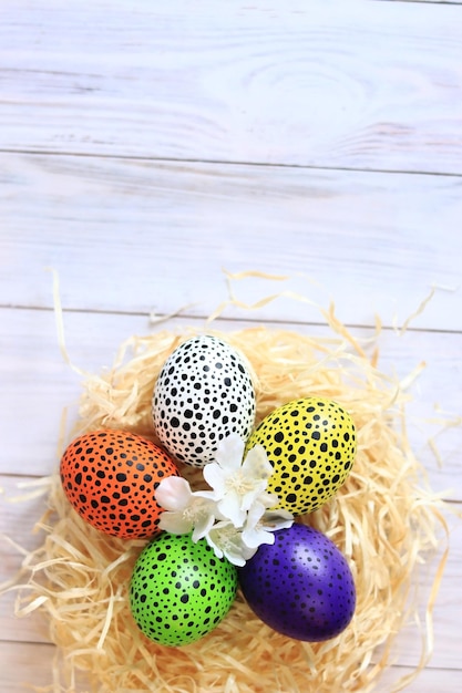 Buona Pasqua Uova di Pasqua in un nido su uno sfondo di legno chiaro vista dall'alto