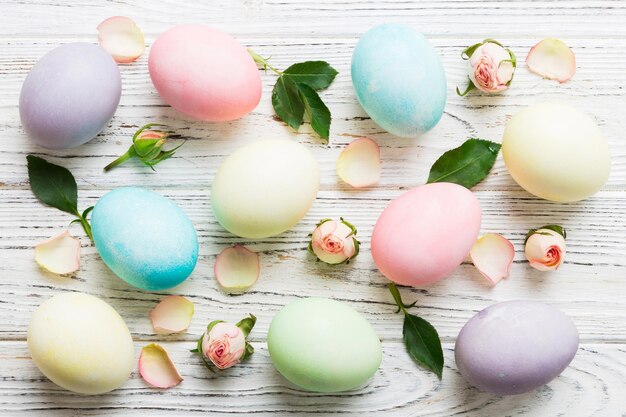 Buona Pasqua Uova di Pasqua su tavolo colorato con rose gialle Uova colorate naturali sfondo vista superiore con spazio di copia