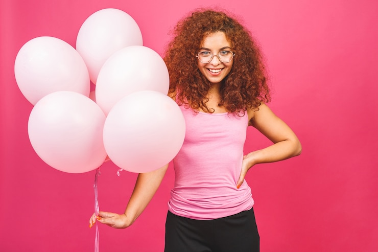 Foto buone vacanze! felice giovane donna sorridente riccia con palloncini
