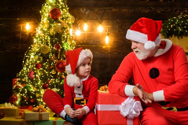 Buone vacanze regalo di natale Babbo Natale uomo e piccolo ragazzo di Babbo Natale a casa buon natale natale