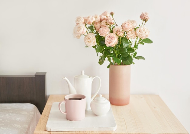 Buongiorno accogliente Bouquet di fiori di rosa in vaso sul tavolo Camera d'hotel con letto Check in hotel Riposo e relax Caffè a letto Colazione romantica San Valentino