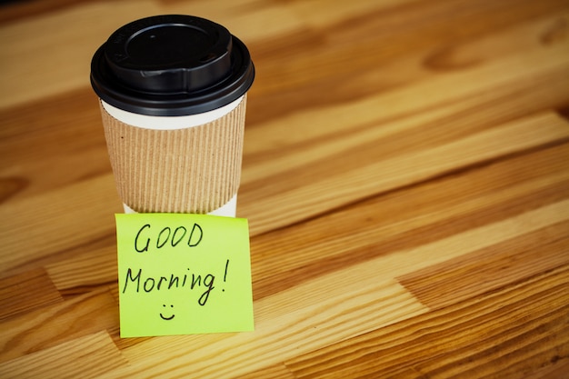 Buongiorno, ora del caffè, caffè per andare e fagioli su un legno