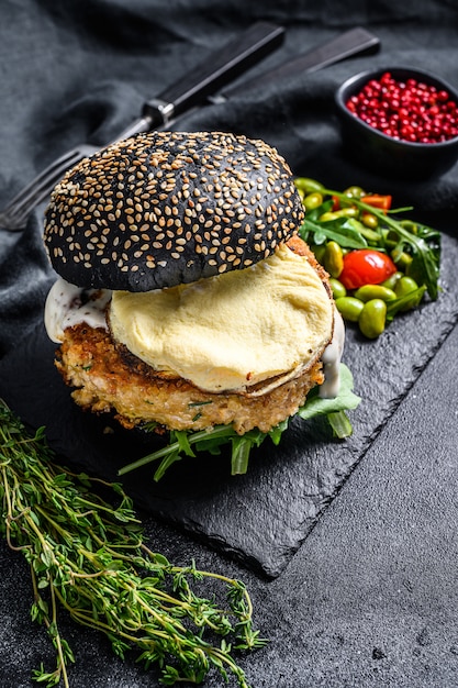 Burger artigianale con panino nero, uova strapazzate e rucola