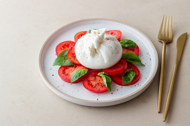 Burrata italiana con pomodori e basilico. Insalata. Mangiare sano. Cibo vegetariano.