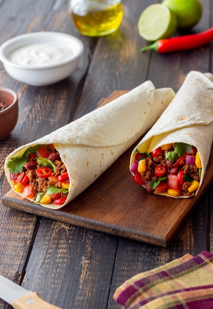 Burrito con carne, fagioli, mais, pomodori, cipolle e peperoncino. Cibo messicano. Ricetta.