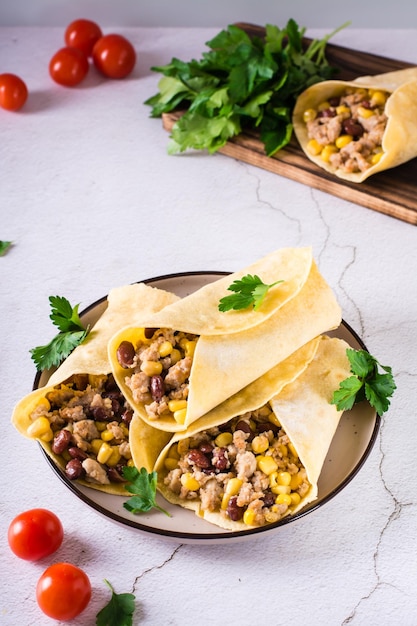 Burrito messicano tradizionale con carne macinata di mais e fagioli su un piatto sul tavolo Vista verticale