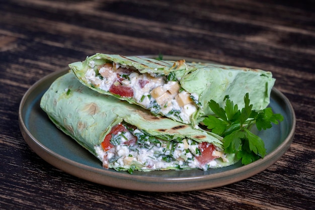 Burrito vegano verde Involucro di cibo crudo affettato con ingredienti vegani su un piatto
