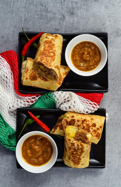 Burritos messicani con chorizo, patate, formaggio e carne di manzo serviti con salsa barracha