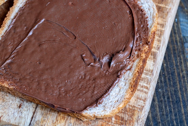 Burro al cioccolato spalmato sul pane mentre si cucina la colazione