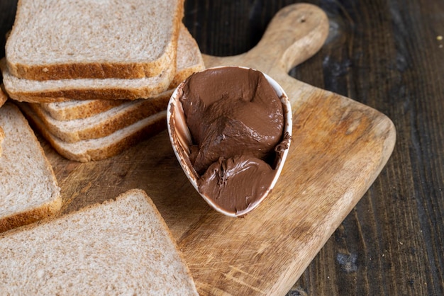 Burro al cioccolato spalmato sul pane mentre si cucina la colazione