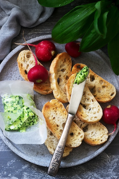 Burro con aglio selvatico, fette di pane e ravanello, ingredienti per preparare un panino.