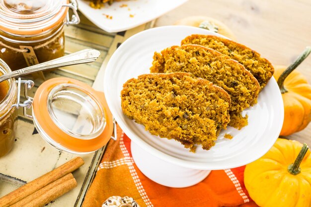 Burro di zucca fatto in casa con pane di zucca sul tavolo.