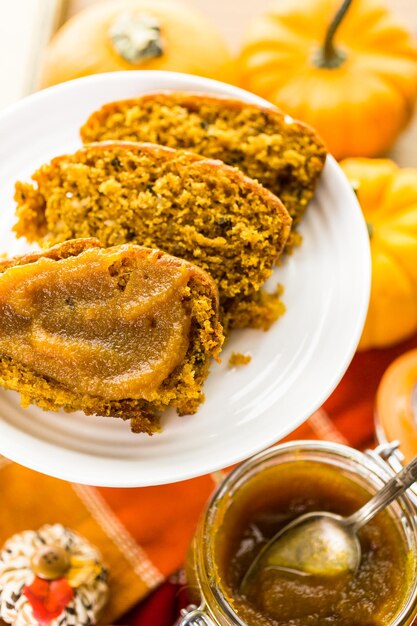 Burro di zucca fatto in casa con pane di zucca sul tavolo.