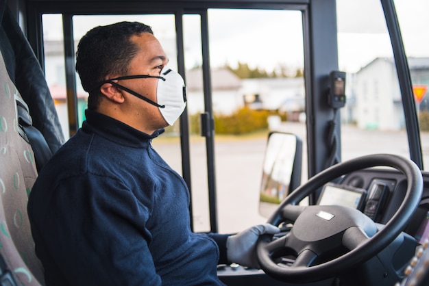 Busdriver con maschera di protezione e guanti guida bus intercity