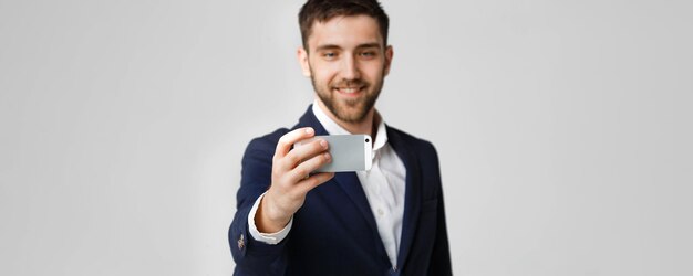 Business Concept Bell'uomo d'affari si fa un selfie con uno sfondo bianco dello smartphone