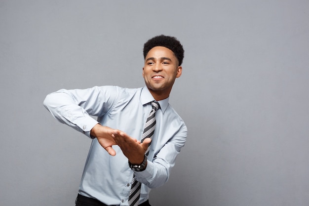 Business Concept - fiducioso felice giovane afroamericano gettando i pugni in aria per celebrare i progetti di successo