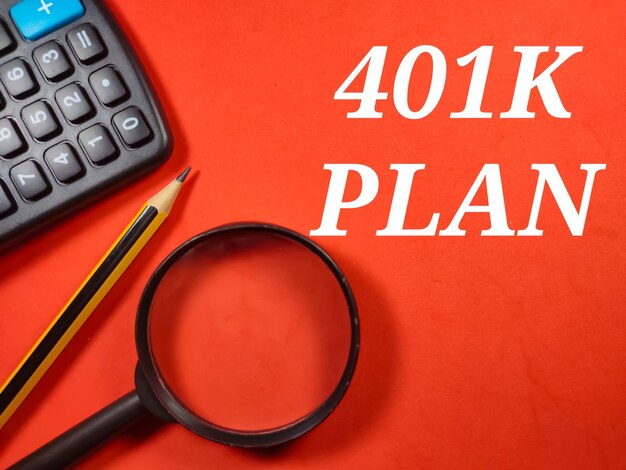 Business conceptText 401K PIANO con lente di ingrandimentomatita e calcolatrice su sfondo rosso