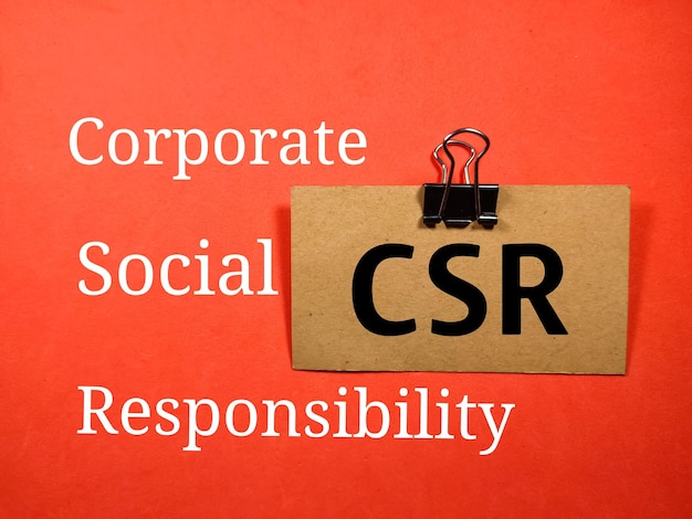 Business conceptText CSR Responsabilità sociale d'impresa scritta su cartoncino marrone su sfondo rosso