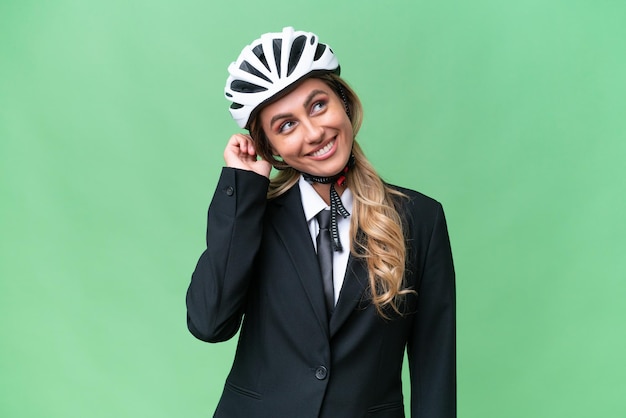 Business donna uruguaiana che indossa un casco biker su sfondo isolato pensando un'idea