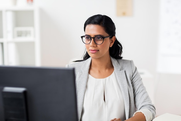 business, persone, lavoro e concetto tecnologico - donna d'affari con computer che lavora in ufficio