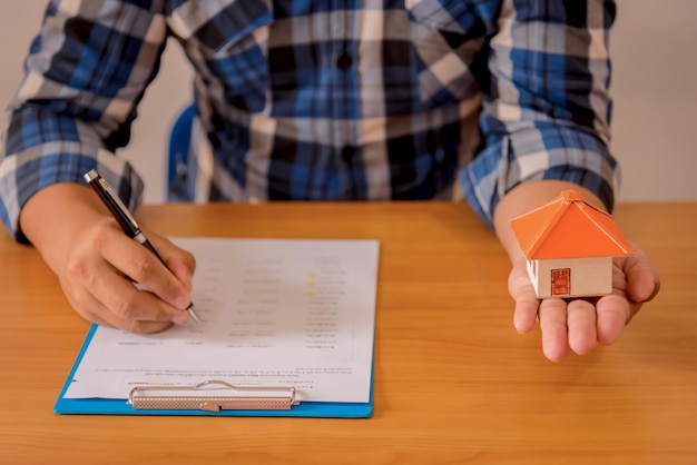 Business Real Estate Concept, modello di casa su sfondo di legno e sfocato.