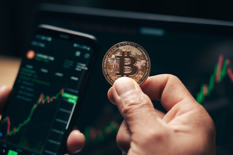 Photo businessman holding golden bitcoin on computer trading chart screen background. stock, cryptocurrency trading concept.