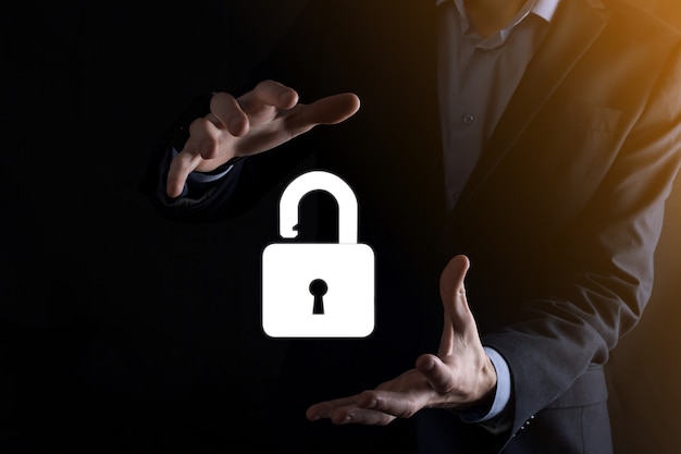Businessman holds an open padlock icon on his palm.unlocking a virtual lock. Business concept and technology metaphor for cyber attack, computer crime, information security and data encryption.