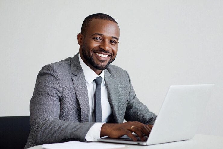 Businessman smiling while working on a laptop duri
