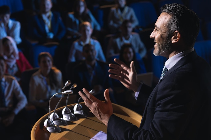 Photo businessman standing and giving presentation in the auditorium