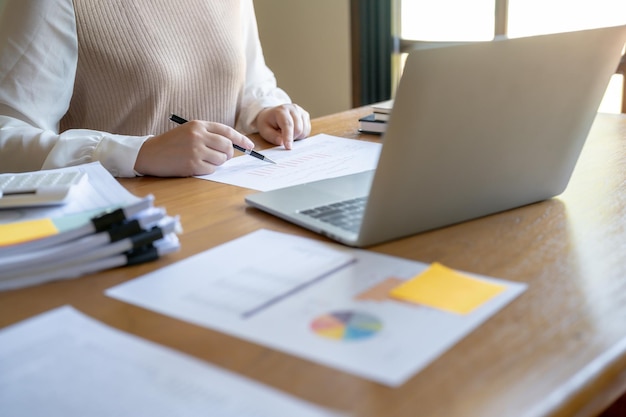 Businesswoman Accountant analizzando i grafici di investimento Fattura e premendo il calcolatore