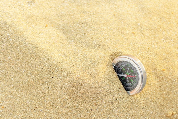 Bussola d'argento magnetica sul fondo della sabbia