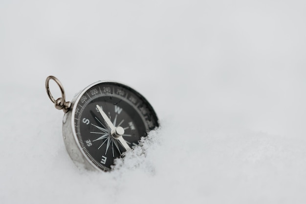 Bussola rotonda nella neve spazio per il testo Navigazione nella foresta invernale Concetto di orienteering nella foresta invernale