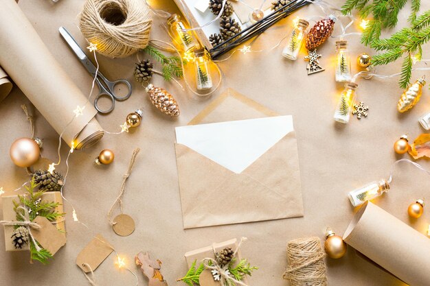 Busta con auguri per Natale e Capodanno in materiali ecologici: carta kraft, rami di abete vivo, pigne, spago. Tag mock up, decoro naturale, fatto a mano. Lettera per Babbo Natale. piatto