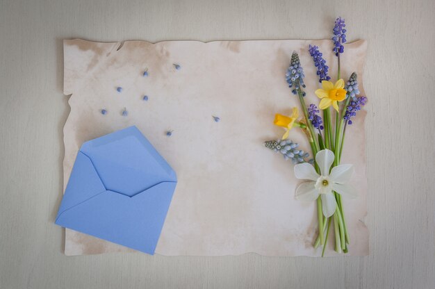 Busta di carta e affrancatura vintage con bouquet di narcisi e fiori di muscari