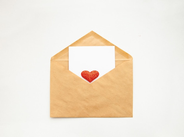 Busta di carta kraft e un cartoncino bianco vuoto con un cuore. Buon San Valentino.