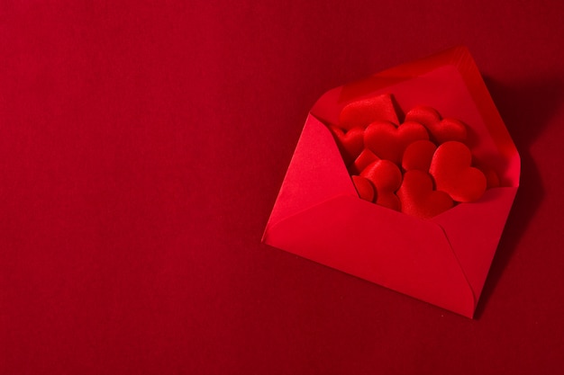 Busta di carta rossa con interno di cuori isolato su spazio rosso Copia spazio concetto di San Valentino