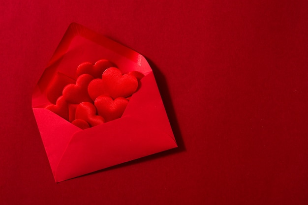 Busta di carta rossa con interno di cuori isolato su spazio rosso Copia spazio concetto di San Valentino