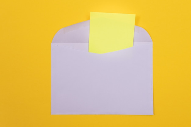 Busta viola con foglio di carta giallo vuoto all'interno