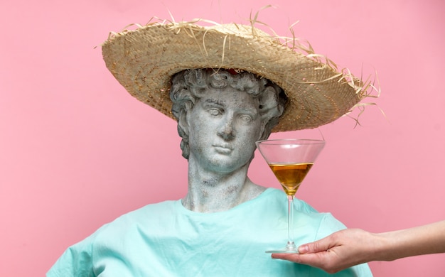 Busto antico del maschio in cappello con bicchiere da martini