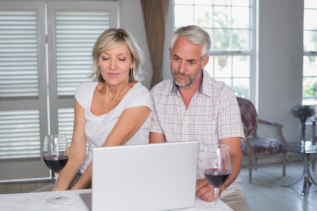 C con bicchieri da vino con laptop a casa