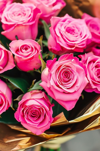 c'è un bouquet di rose rosa in un involucro d'oro generativo ai