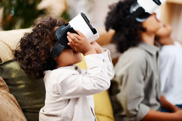 C'è un mondo completamente nuovo là fuori Inquadratura ritagliata di tre ragazzini che guardano film insieme attraverso le cuffie per realtà virtuale a casa