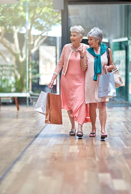 C'è una vendita che ha attirato la mia attenzione Inquadratura a figura intera di due donne anziane a fare shopping