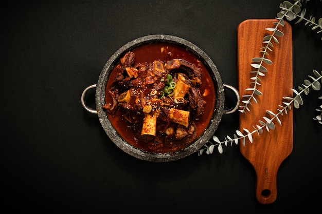 C'è una zuppa di carne in una ciotola Lo sfondo è una trama nera